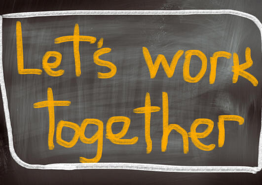 The text 'Let's work together' on a black-board